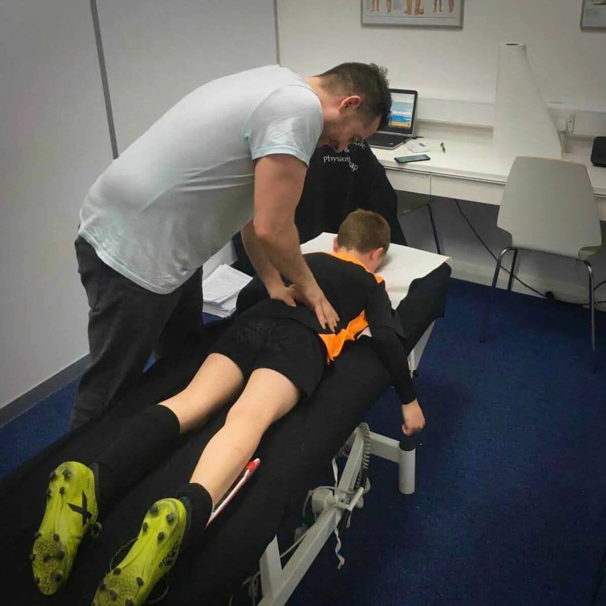 Chiropractor treating a patient lying face down on a treatment table
