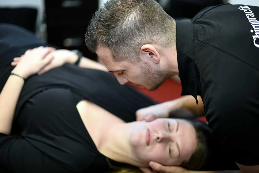 Chiropractor at MGM Clinics adjusting a patient's neck on a treatment table