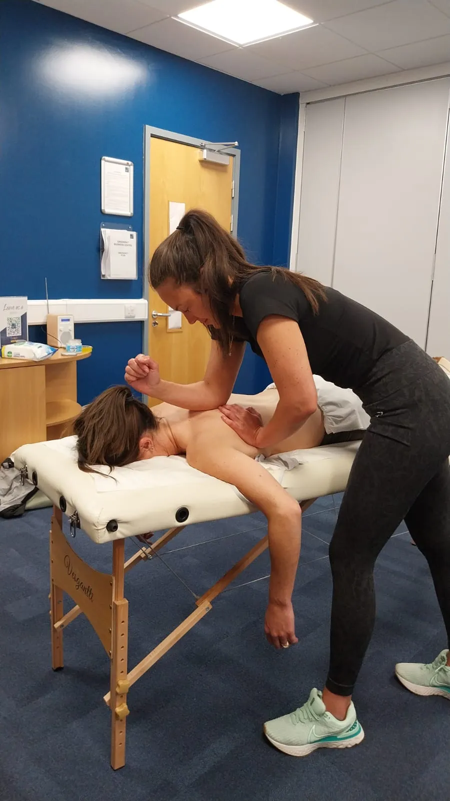 Massage therapist treating a patient on a portable couch